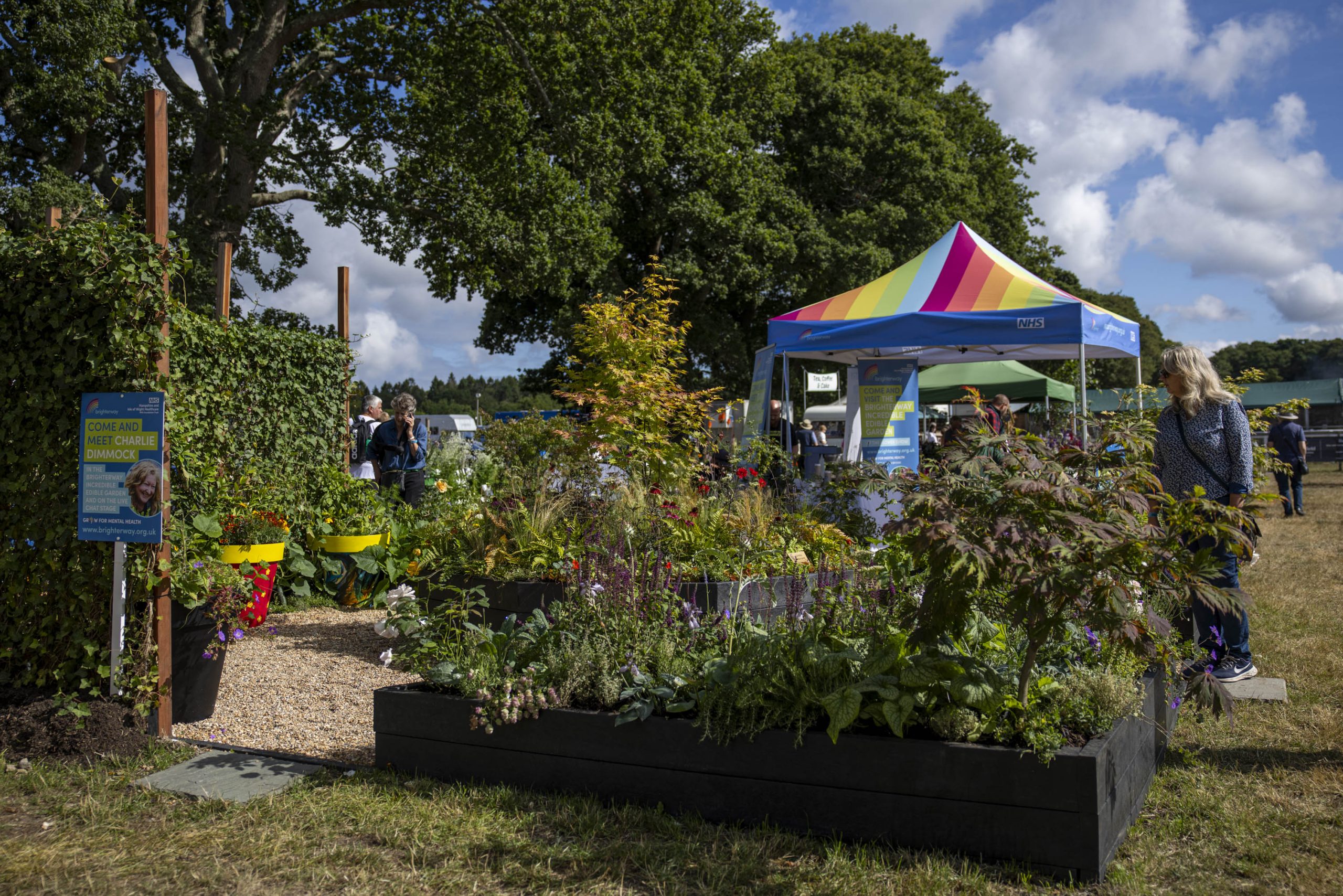 A multicoloured tent in a lush garden exhibit at the New Forest Show 2025